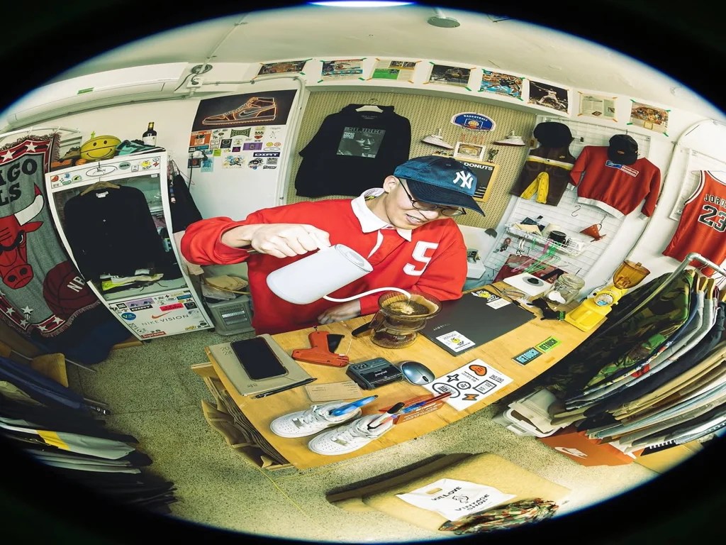 Retouch Seoul owner brewing coffee inside the vintage store, surrounded by rare streetwear, sneakers, and collectibles.