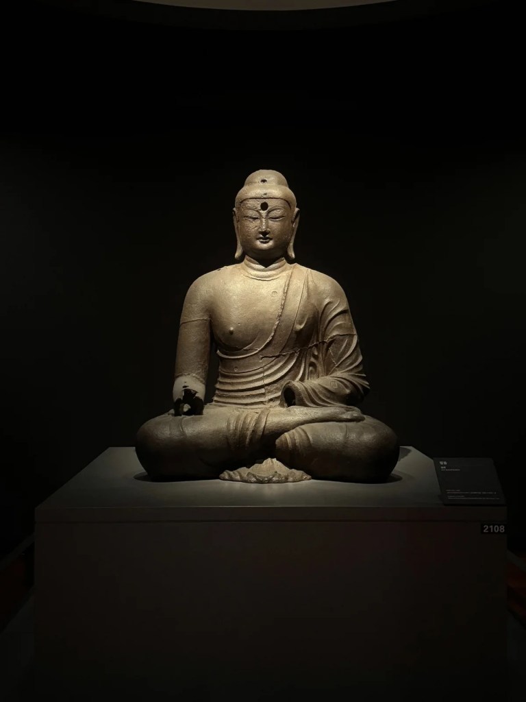 Ancient Buddha statue displayed in a spacious exhibition hall at the National Museum of Korea.
