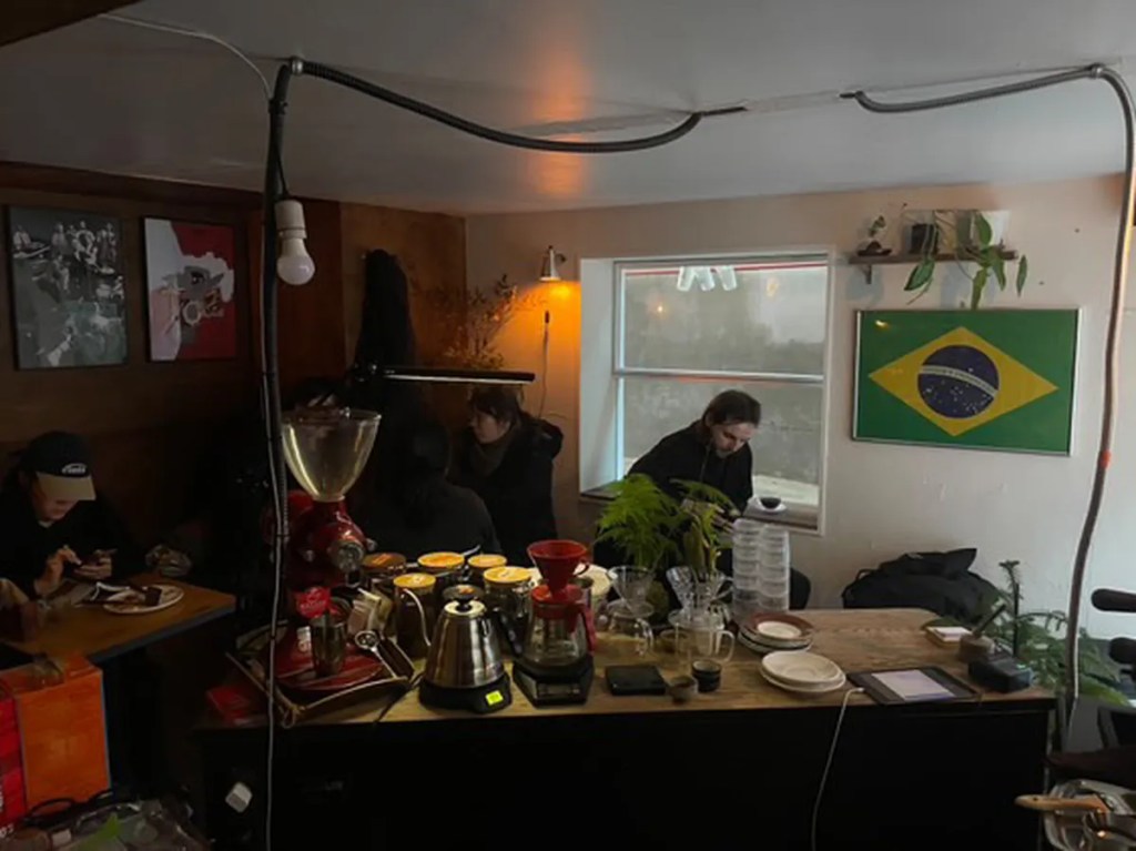 A Brazilian flag hanging on the wall inside Guden Guden Cafe in Seoul, highlighting the cafe’s unique international ambiance and cozy aesthetic.
