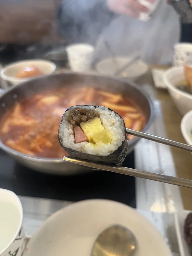 mini gimbap served with dipping sauce and side dishes