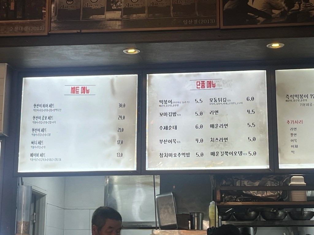 Digital menu screen at Hyunseonine showing set menus, tteokbokki options, and side dishes