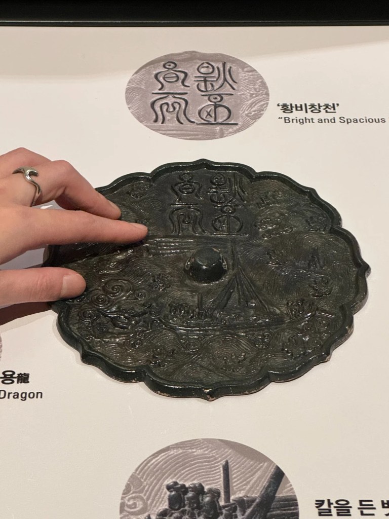 Touchable bronze mirror artifact, allowing visitors to experience traditional Korean craftsmanship up close.